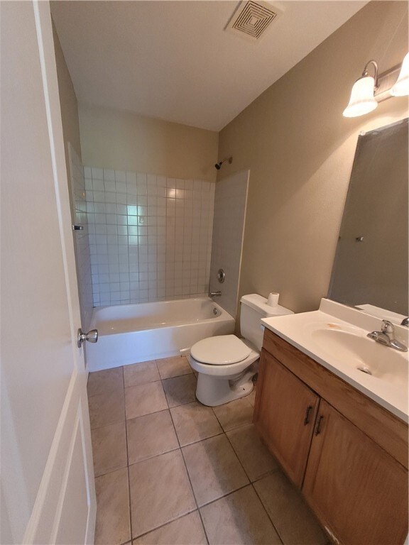 full bathroom with vanity, tile patterned flooring, toilet, and tiled shower / bath combo