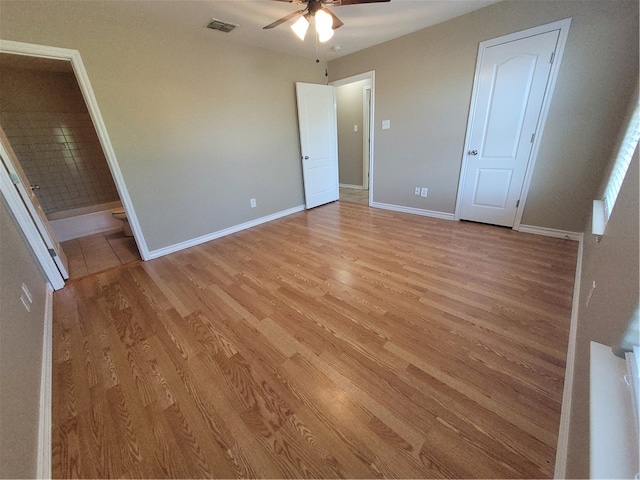 unfurnished bedroom featuring connected bathroom, ceiling fan, and light hardwood / wood-style flooring