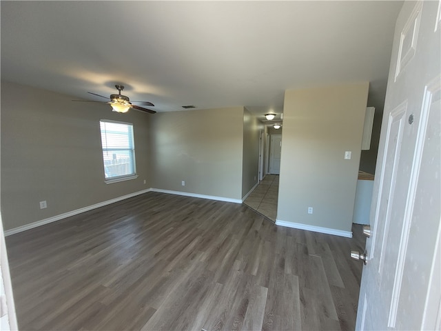 empty room featuring dark wood-type flooring and ceiling fan