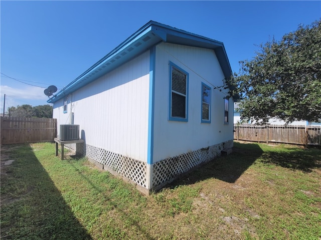 view of property exterior with central AC unit and a yard