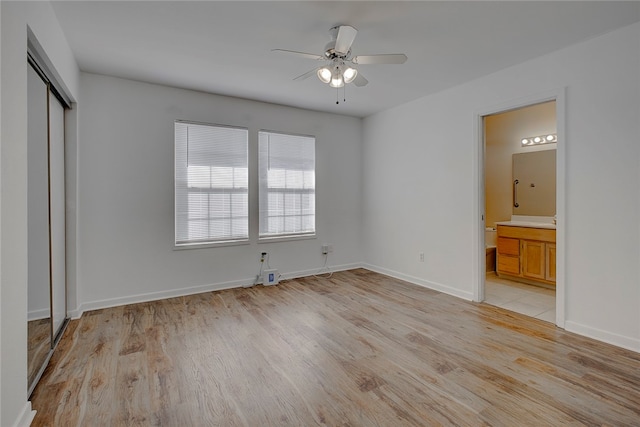 unfurnished bedroom with a closet, ceiling fan, light hardwood / wood-style flooring, and ensuite bathroom