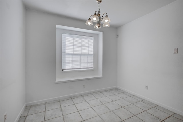 empty room featuring light tile patterned flooring and a chandelier