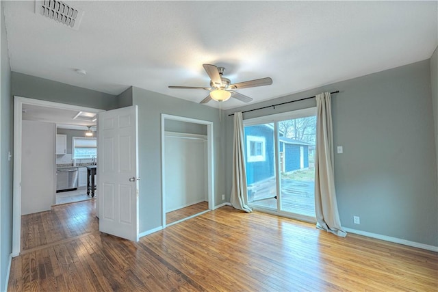 unfurnished bedroom featuring baseboards, visible vents, light wood-style flooring, access to outside, and a closet