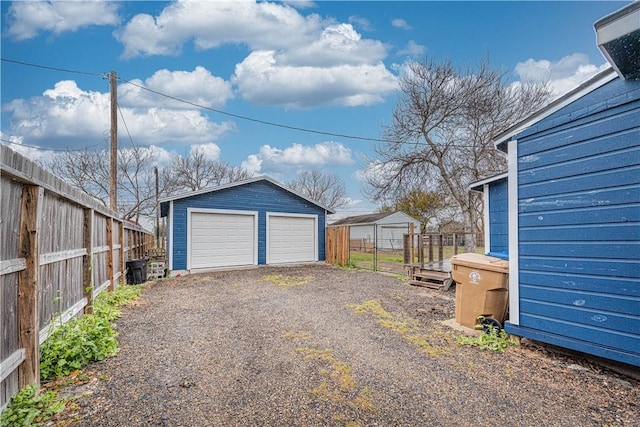 detached garage featuring fence