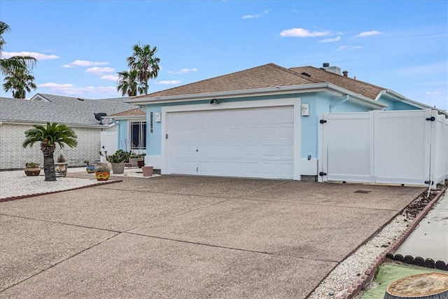 single story home with an attached garage, driveway, fence, and roof with shingles