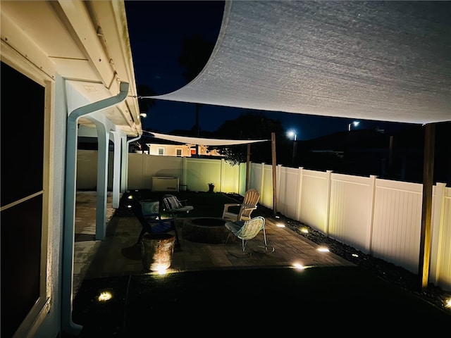 patio at night with a fenced backyard