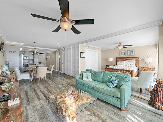 living room featuring crown molding, ceiling fan, and wood-type flooring