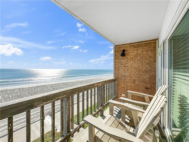 balcony with a water view and a beach view