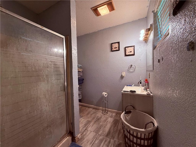 5742 Hidden Valley Loop, Sandia, TX 78383 - bathroom featuring a shower stall, vanity, wood finished floors, and a textured wall