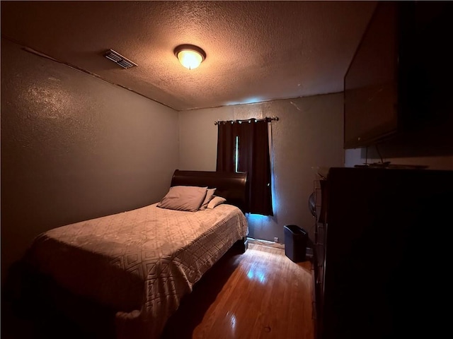 5742 Hidden Valley Loop, Sandia, TX 78383 - bedroom featuring a textured ceiling, wood finished floors, and a textured wall