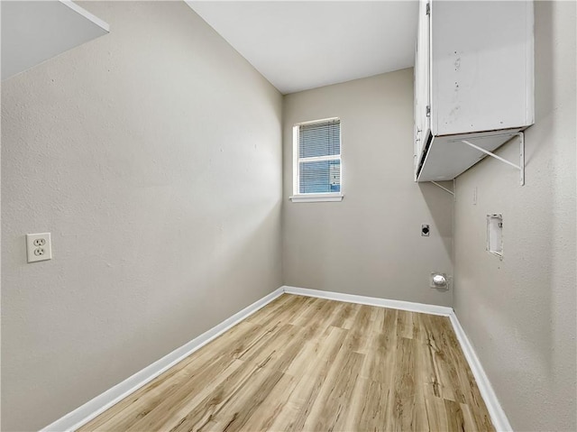 laundry area featuring hookup for an electric dryer, washer hookup, baseboards, light wood-type flooring, and cabinet space