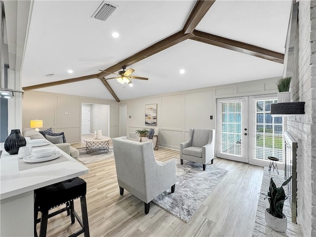 living room featuring french doors, vaulted ceiling with beams, visible vents, a decorative wall, and light wood-style floors