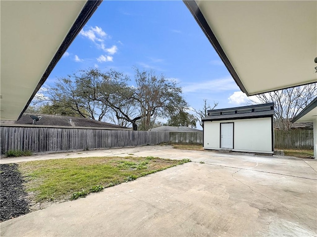 view of yard featuring a fenced backyard, an outdoor structure, and a patio