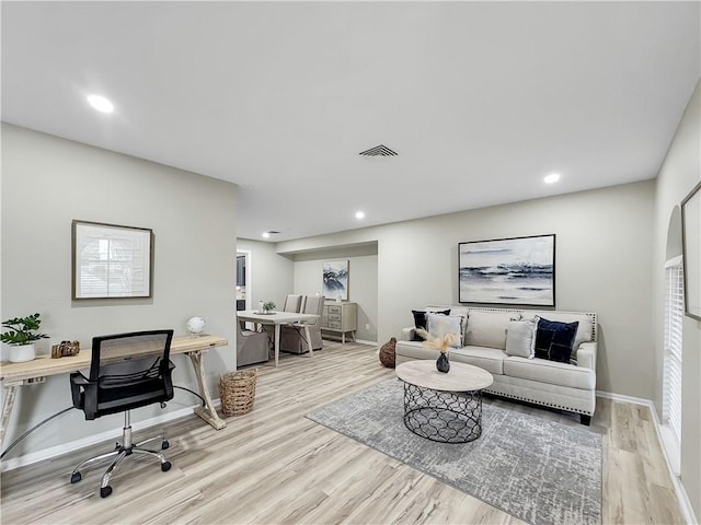 living area with baseboards, wood finished floors, and recessed lighting