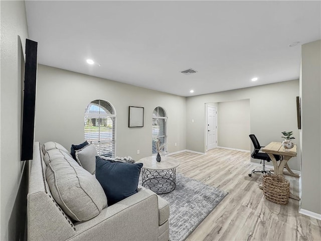 living room with light wood finished floors, baseboards, visible vents, and recessed lighting