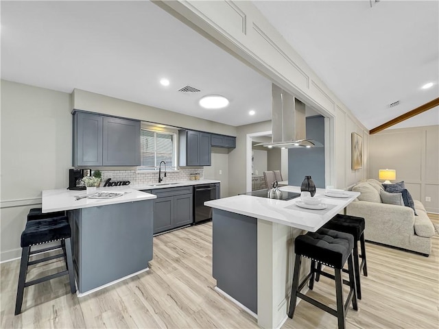 kitchen with visible vents, a sink, black appliances, a peninsula, and a kitchen breakfast bar