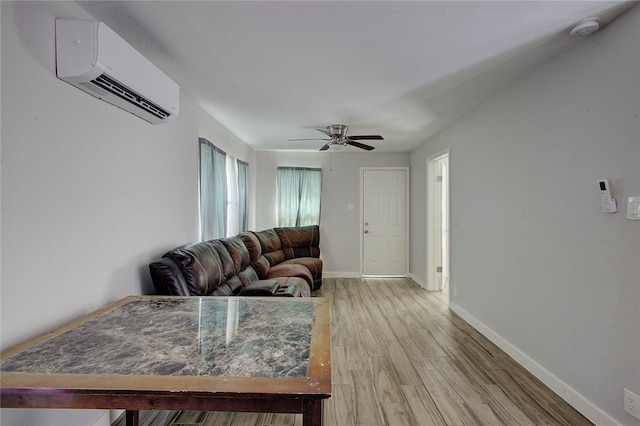 living room with hardwood / wood-style flooring, an AC wall unit, and ceiling fan