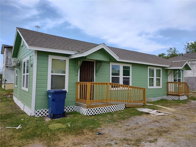 view of front facade featuring a front yard and a wooden deck