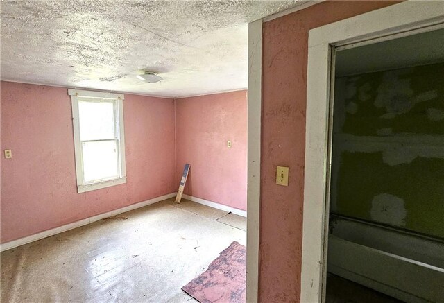 411 E Sarah St, Beeville, TX 78102 - unfurnished room with baseboards, a textured ceiling, and concrete flooring