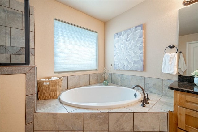 bathroom featuring vanity and a relaxing tiled tub