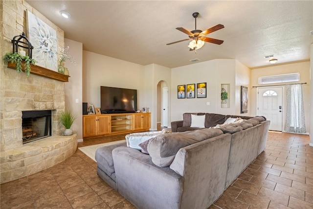 living room with a fireplace and ceiling fan