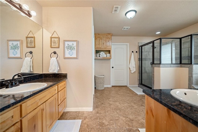 bathroom with vanity and a shower with door