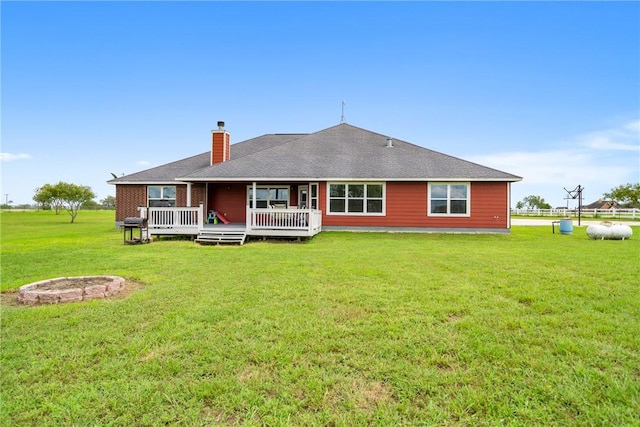 back of property with a deck and a lawn