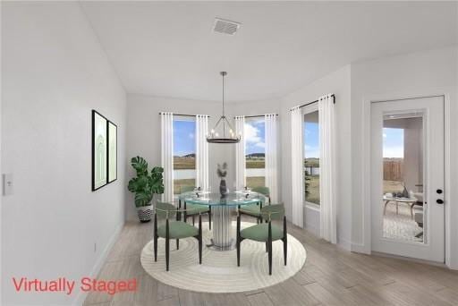 dining area featuring an inviting chandelier, baseboards, visible vents, and light wood finished floors