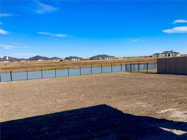 property view of water featuring a residential view and fence