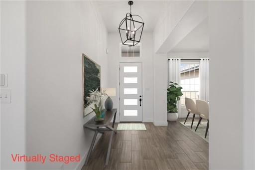 foyer featuring an inviting chandelier, wood finished floors, and baseboards