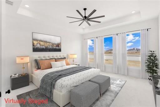 bedroom with a tray ceiling, multiple windows, access to exterior, and recessed lighting