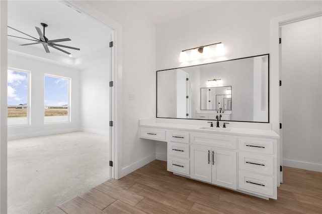 bathroom featuring ceiling fan, baseboards, wood finished floors, and vanity