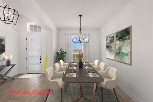 dining room with wood finished floors, baseboards, and a chandelier