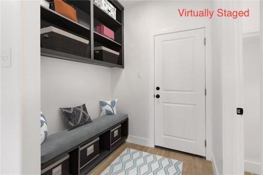 mudroom with light wood finished floors and baseboards