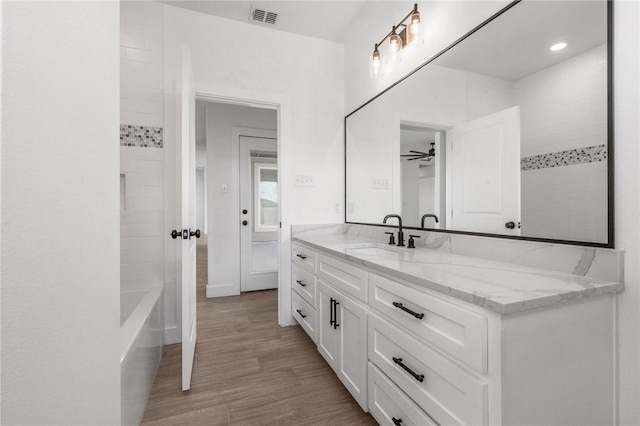 full bathroom with visible vents, a ceiling fan, wood finished floors, and vanity