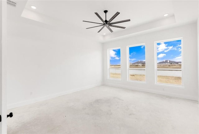 unfurnished room with recessed lighting, baseboards, and a tray ceiling