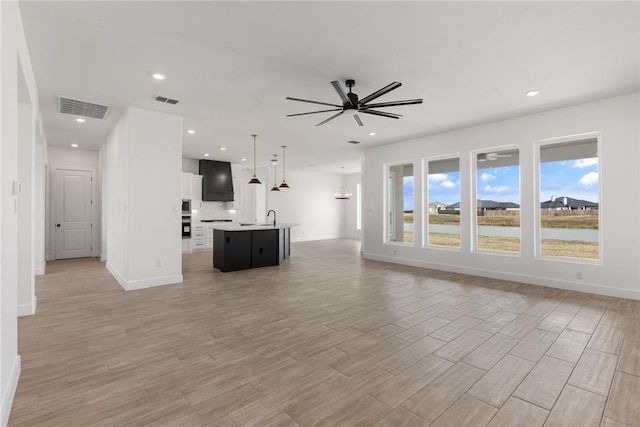 unfurnished living room with light wood finished floors, visible vents, recessed lighting, and ceiling fan