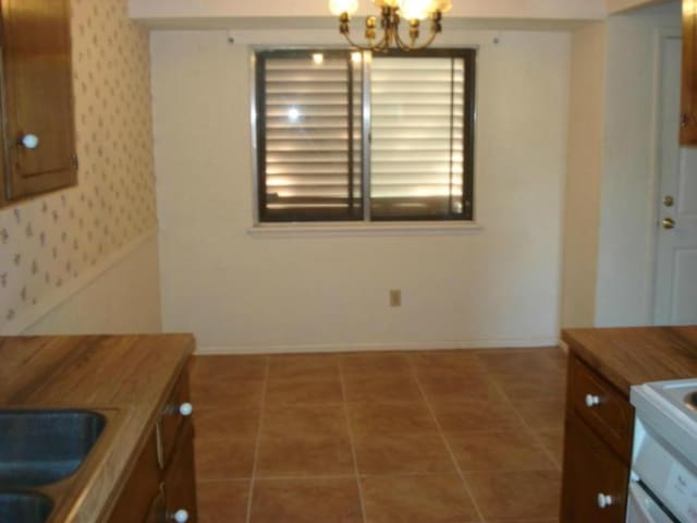 tiled dining area with sink and an inviting chandelier