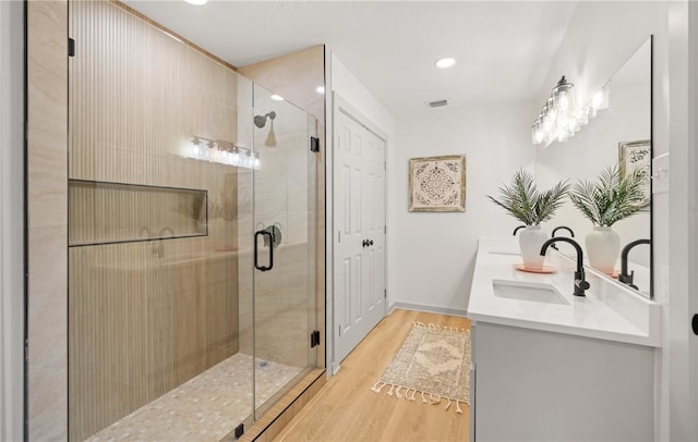 6905 Braesvalley Dr, Corpus Christi, TX 78413 - bathroom with double vanity, a shower stall, wood finished floors, and recessed lighting
