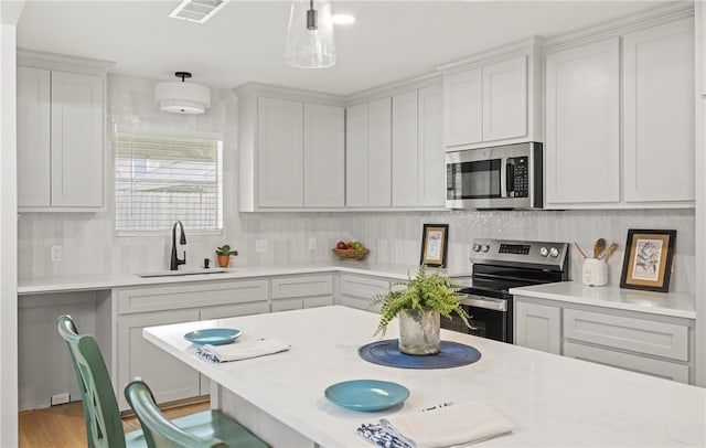 6905 Braesvalley Dr, Corpus Christi, TX 78413 - kitchen with appliances with stainless steel finishes, light countertops, backsplash, and a kitchen breakfast bar