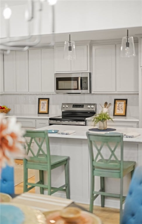 6905 Braesvalley Dr, Corpus Christi, TX 78413 - kitchen with stainless steel appliances, a kitchen breakfast bar, light countertops, backsplash, and pendant lighting