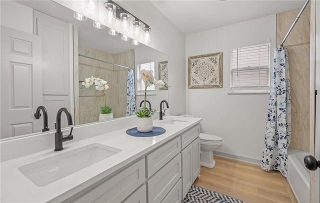 6905 Braesvalley Dr, Corpus Christi, TX 78413 - full bathroom with double vanity, shower / tub combo with curtain, and wood finished floors