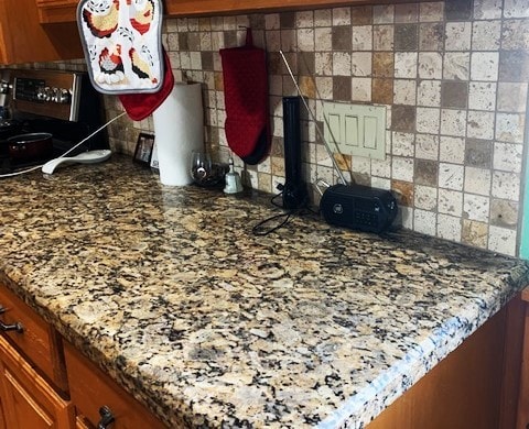 interior details featuring stone countertops and tasteful backsplash