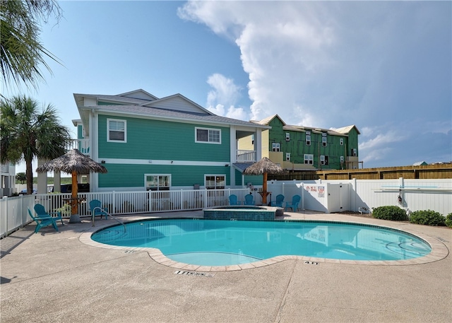 view of pool featuring a community hot tub and a patio area