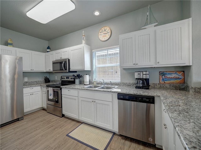 kitchen with appliances with stainless steel finishes, sink, and white cabinets