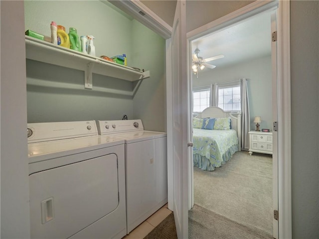 laundry area with washing machine and dryer, light carpet, and a ceiling fan