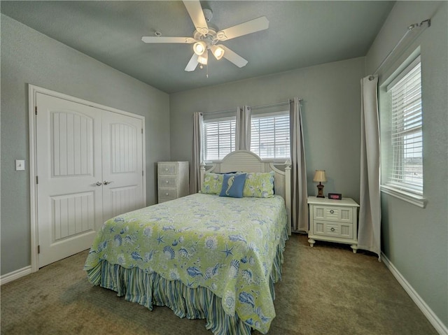 carpeted bedroom with multiple windows, a closet, baseboards, and a ceiling fan