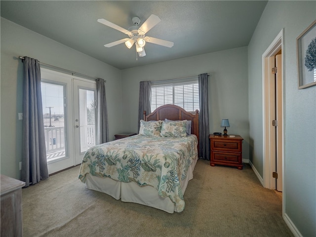 carpeted bedroom with french doors, ceiling fan, and access to exterior