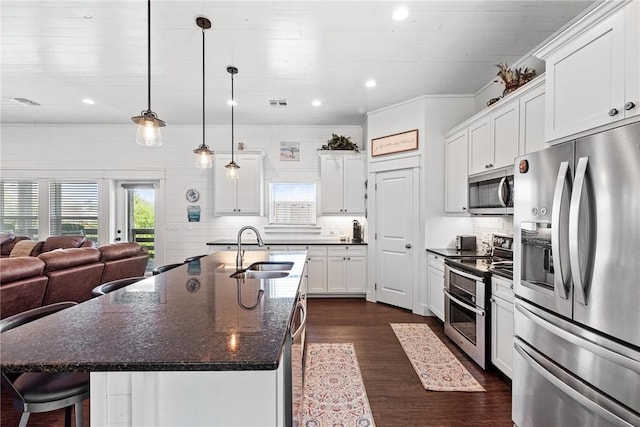 kitchen with appliances with stainless steel finishes, a sink, white cabinetry, and plenty of natural light