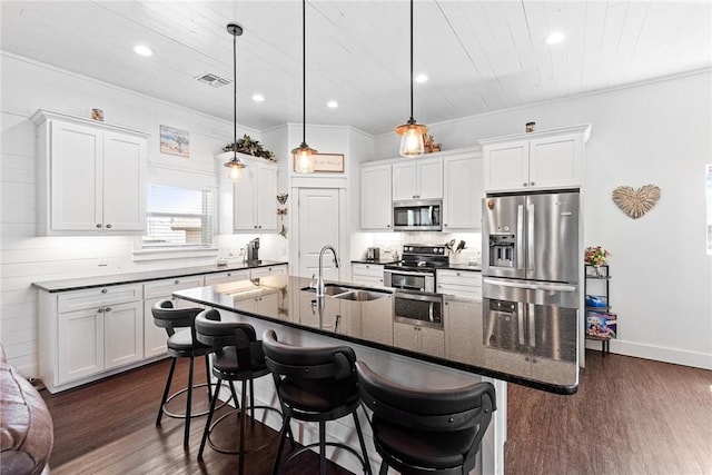kitchen featuring stainless steel appliances, tasteful backsplash, visible vents, and a sink